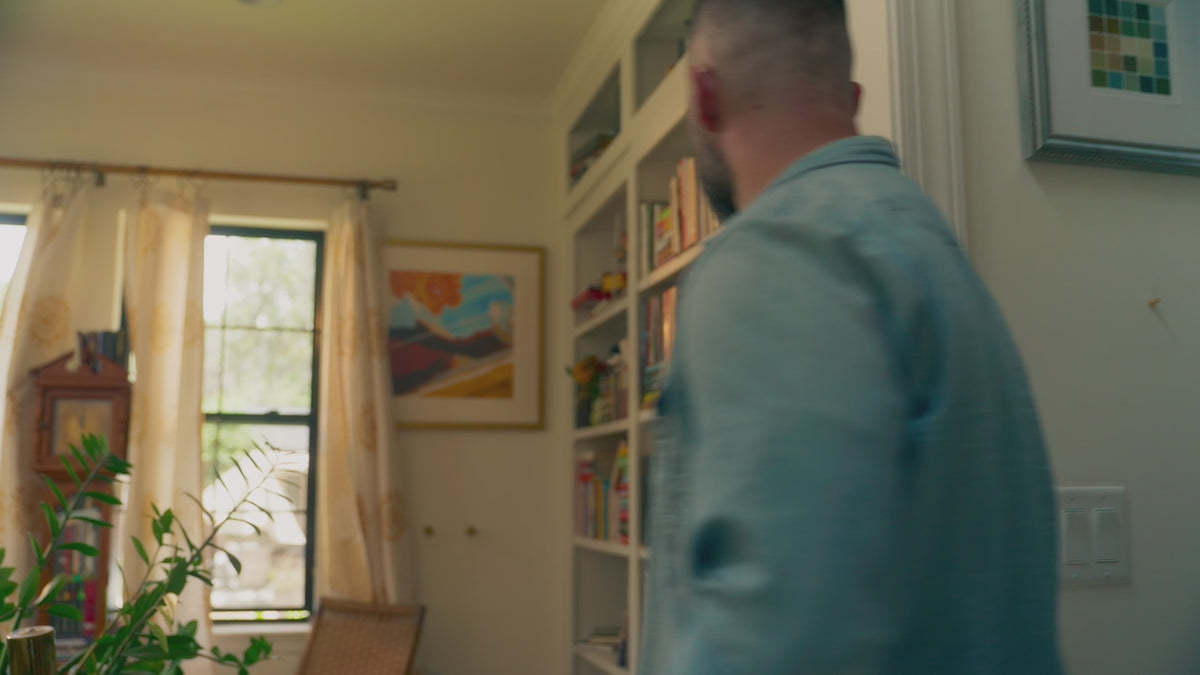 Load video: A video of a man selecting the coffee table book featured and leafing through the book as he reflects on his own memories
